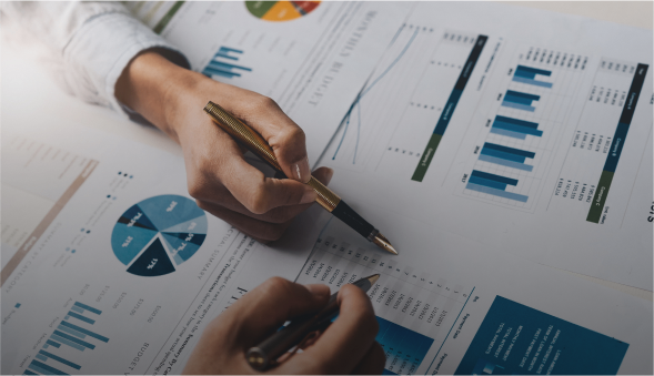 Hands analyzing charts and graphs on paper.